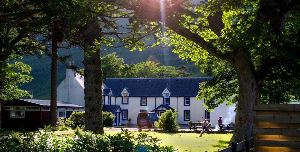 Hartfield Header Hartfield hostel with trees surrounding it and people having a bbq in the garden
